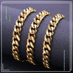 Gold-tone polished Cuban link chains displayed on a textured dark surface, featuring a classic hip hop style design.