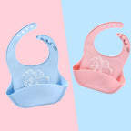 Blue and pink silicone baby bibs with elephant prints, featuring adjustable neck straps and a large food-catching pocket.