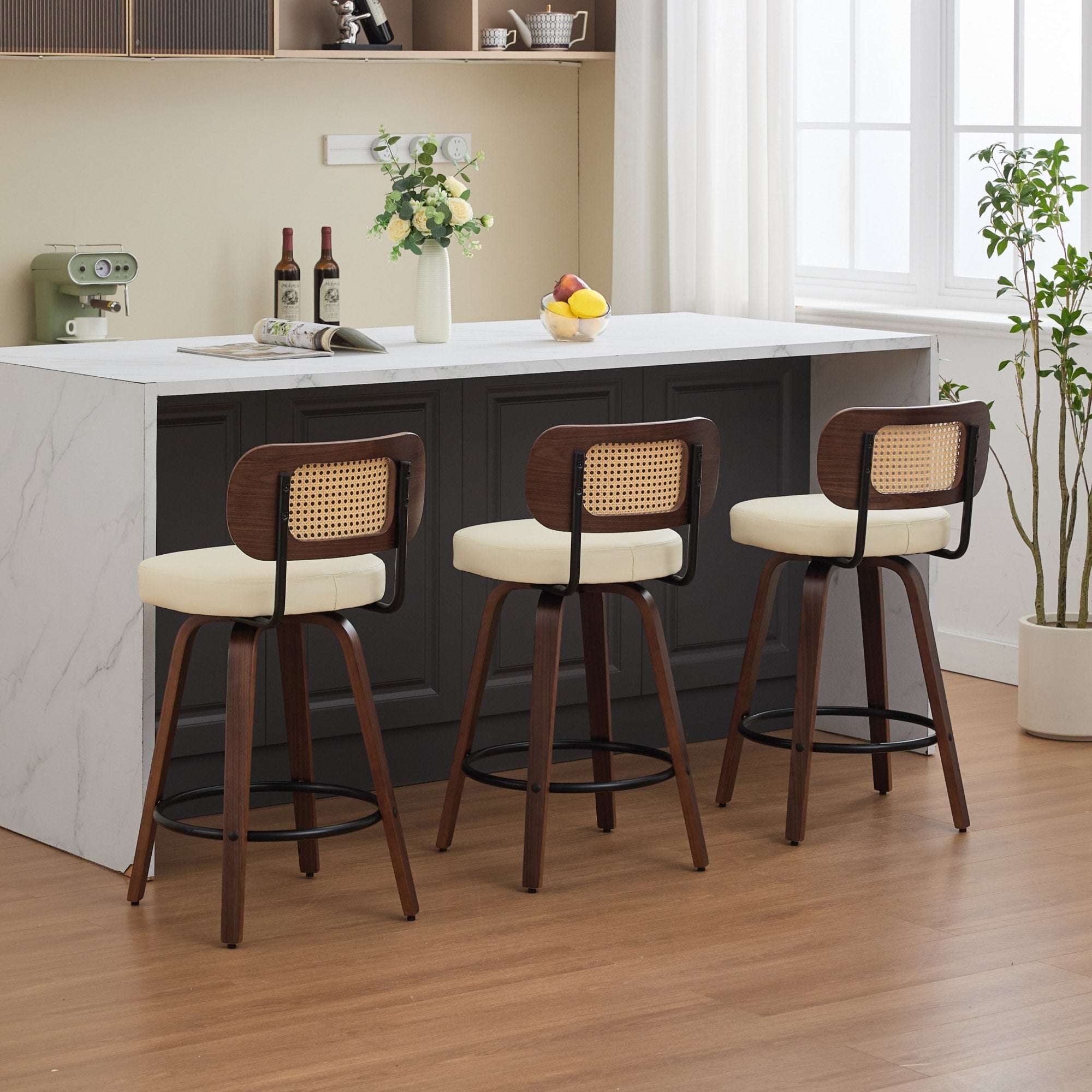 Set of 3 walnut swivel counter stools with cane backs and beige upholstered seats at a kitchen island.