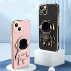 Pink and black phone cases with 3D astronaut kickstands and gold-electroplated edges for shockproof protection.