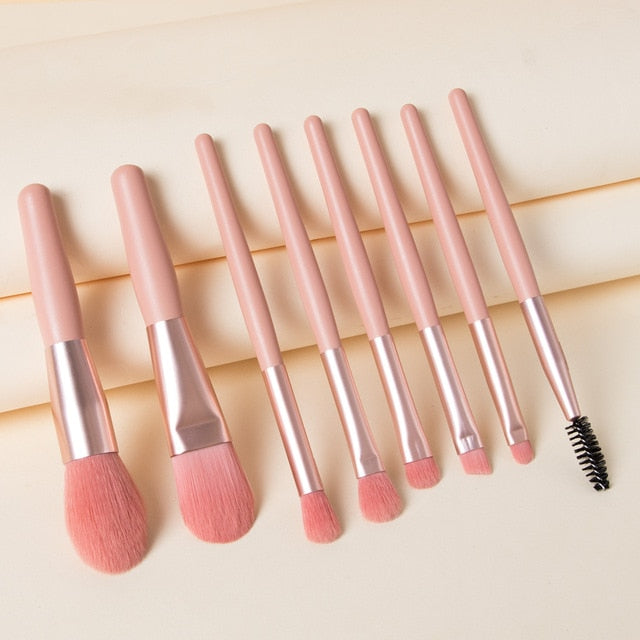 A portable 7-piece makeup brush set featuring pink handles, rose gold ferrules, and soft pink bristles.