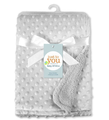 White, soft-touch dimpled baby blanket with ribbon and "Just to You" brand tag. Texture has raised dots.