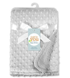 White, soft-touch dimpled baby blanket with ribbon and "Just to You" brand tag. Texture has raised dots.