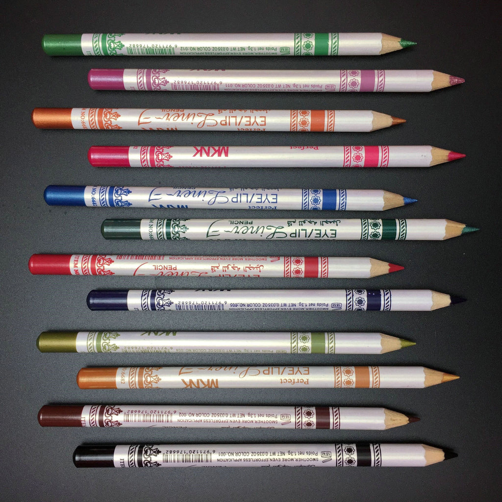 Twelve glittery eye and lip liner pencils in various colors arranged horizontally against a dark background.