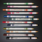Twelve glittery eye and lip liner pencils in various colors arranged horizontally against a dark background.
