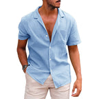 Light blue short-sleeve button-down shirt with an open camp collar, featuring a textured, linen-like casual fit.