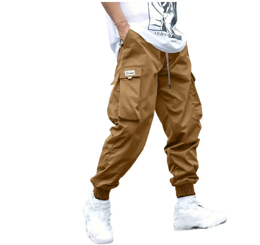Brown, relaxed-fit cargo pants with side pockets, drawstring waist, and elastic cuffs in a street-style design.