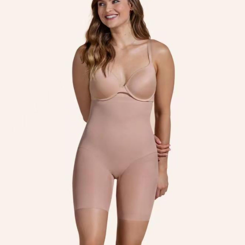 Woman wears high-waisted, beige nude body sculpting shorts for tummy control and hip lifting. Smooth, seamless fabric.