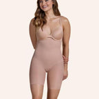 Woman wearing nude, high-waisted seamless shapewear shorts that provide tummy control and hip lifting.