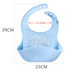 Light blue silicone baby bib with elephant print, crumb catcher pocket, and adjustable button strap. Dimensions included.