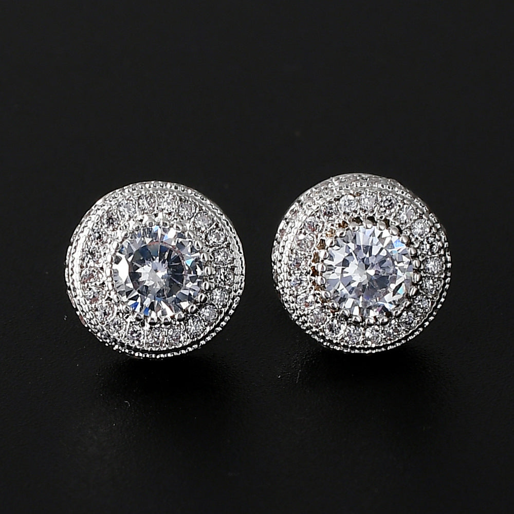 Silver-tone 10mm stud earrings featuring a central round clear stone surrounded by a pavé-set halo on a black background.