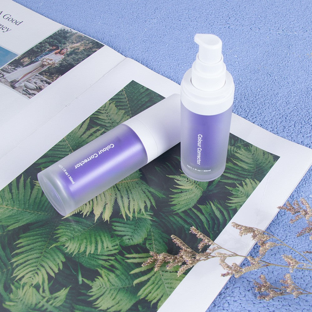 Two purple pump bottles of V34 colour corrector toothpaste on a botanical print magazine over a textured blue surface.