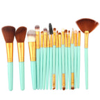 Makeup brush set with mint green handles, gold ferrules, and soft brown and white synthetic bristles on white background.