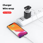 Black silicone power adapter cover with a built-in cable wrap, attached to a charger plugged into a power strip.