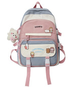 Korean-style pastel color-blocked backpack with utility buckles, plush charm, and cute character patches.