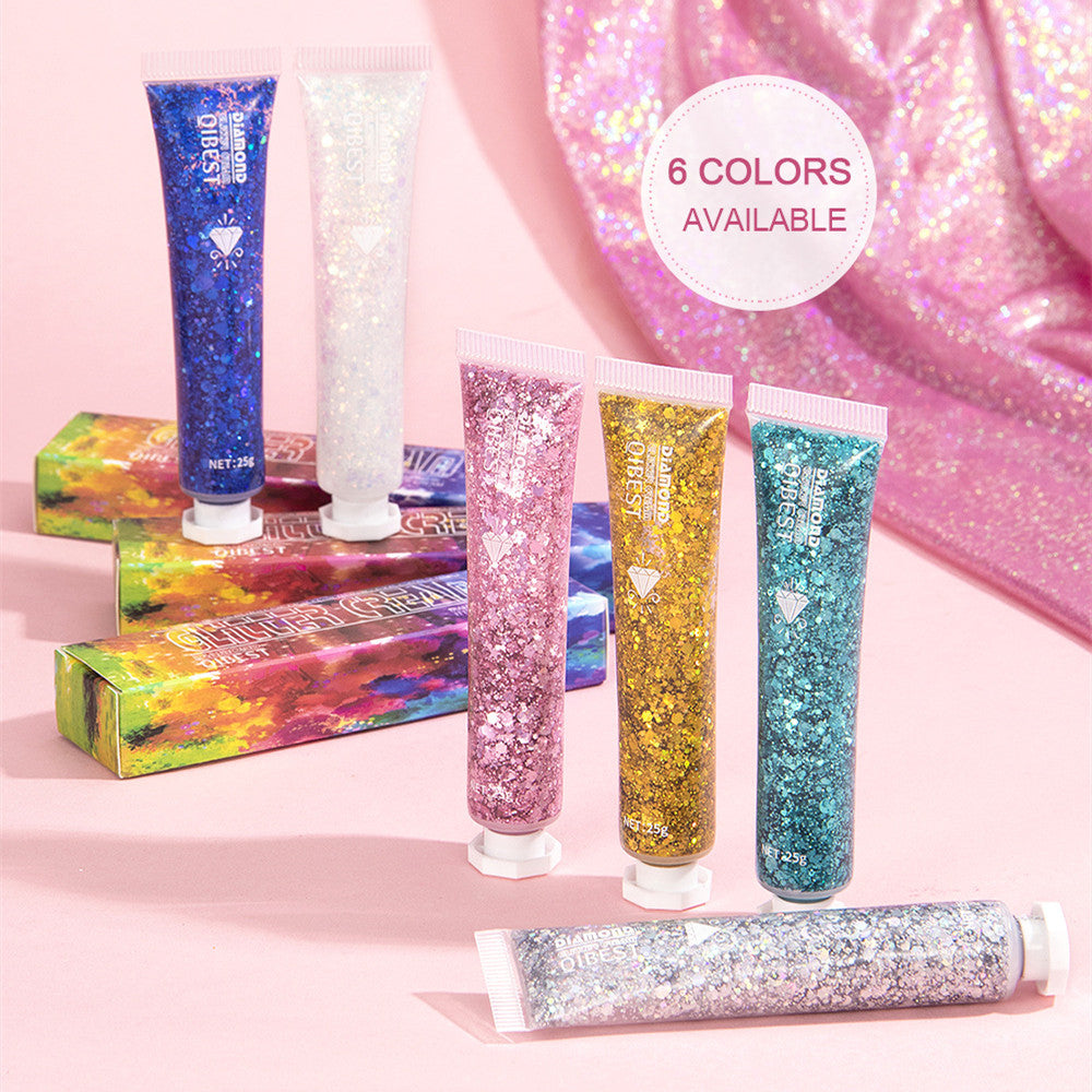Five tubes of colorful glitter cream for face and body, shown with matching patterned boxes on a pink background.