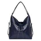 A navy blue, soft leather multifunctional shoulder bag and backpack with two prominent front zipper pockets.