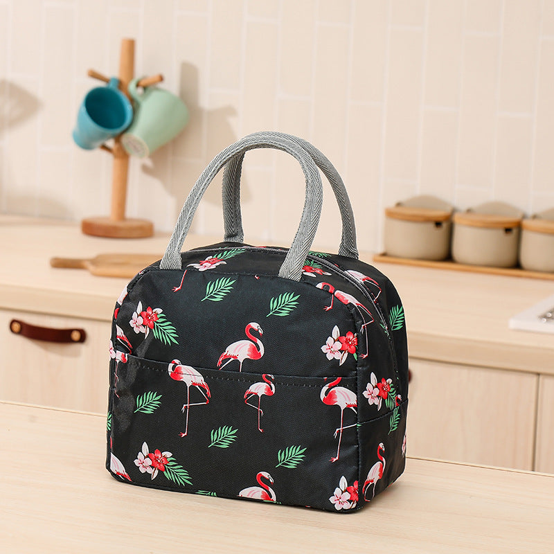 Black waterproof thermal lunch bag with a pink flamingo and leaf print, featuring grey fabric handles and a front pocket.
