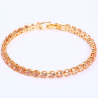 Gold-tone tennis bracelet featuring micro-inlaid round orange zircon stones in a classic prong setting.
