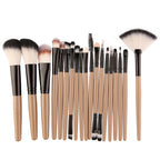 A set of makeup brushes with tan handles, black ferrules, and dual-toned synthetic bristles, including a fan brush.