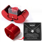 Red apple-shaped gift box containing an eternal rose and a "To My Loving Mom" necklace in a display box.