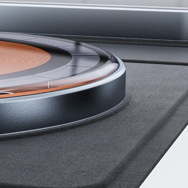 Close-up of a 3-in-1 magnetic wireless charger with a transparent circular coil design and matte gray base.