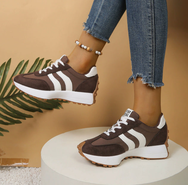 Women’s brown suede and fabric lace-up sneakers with white side stripes, white thick soles, and gum-colored tread.