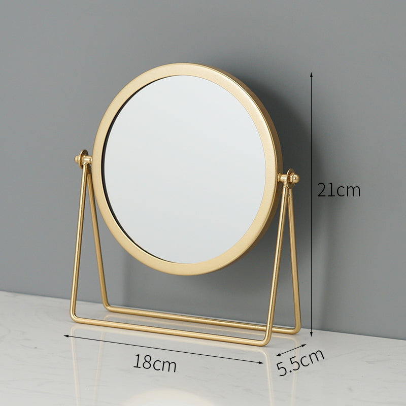 Round gold-framed tabletop makeup mirror on a rotating stand. Dimensions: 21cm height, 18cm width, 5.5cm depth.