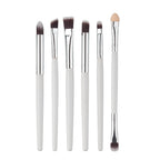 Set of 6 eye makeup brushes with white handles, silver ferrules, and brown synthetic or sponge tips on white background.