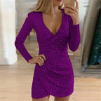 A woman wears a long-sleeve, deep V-neck, purple sequined mini dress with a ruched, irregular wrap-style skirt.