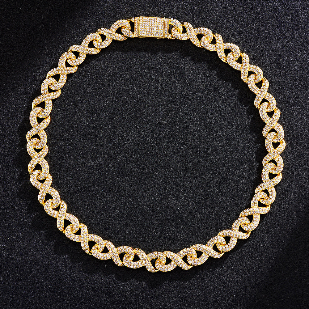 Gold-tone hip hop chain featuring infinity-shaped links fully paved with sparkling clear crystals against black fabric.