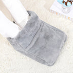 Plush gray electric foot warmer on a white rug, featuring a soft, fuzzy texture with feet inserted inside.