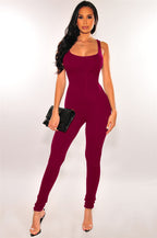 Model wearing a form-fitting, sleeveless, deep maroon casual jumpsuit in a soft, stretchy fabric.