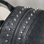 Black leather backpack with embossed skull patterns and silver metal rivet studs along the zipper.