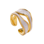 Gold titanium steel open-toed ring with wavy, iridescent white enamel inlay on a white background.