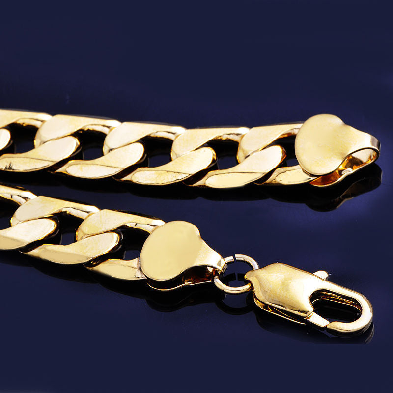 Gold-tone hip hop cuban link chain necklace with a lobster claw clasp, set against a dark blue background.