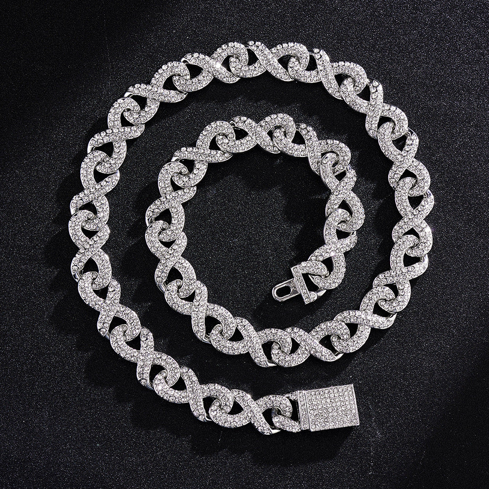 Silver-toned hip hop chain featuring infinity-shaped links encrusted with sparkling clear crystals on a black background.