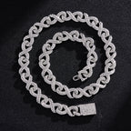 Silver-toned hip hop chain featuring infinity-shaped links encrusted with sparkling clear crystals on a black background.