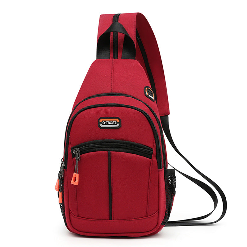Red canvas crossbody sling backpack with black trim, multiple zipper compartments, side mesh pocket, and USB port.