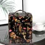 Black glossy makeup bag with a fashion print, top handle, and dual zippers, sitting on a glass table.