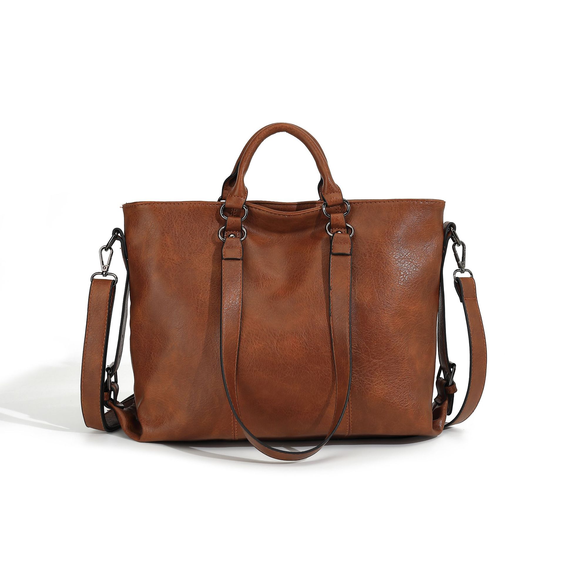 Large brown soft leather tote bag with top handles, detachable shoulder strap, and dark hardware on white background.
