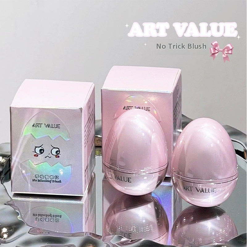 Two glossy pink, egg-shaped blush containers and their iridescent boxes sit on a reflective silver tray.