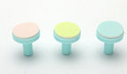Three replacement nail trimmer heads with light blue plastic bases and textured pads in pink, yellow, and blue.