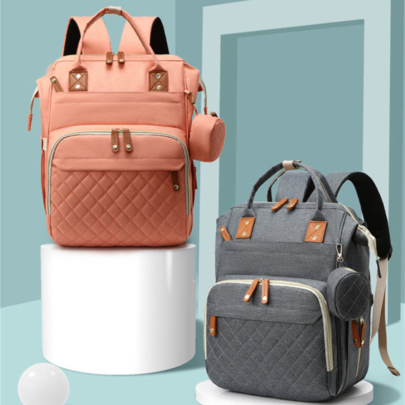 Two multifunctional USB mummy backpacks in peach and grey with diamond-quilted pockets and matching side pouches.