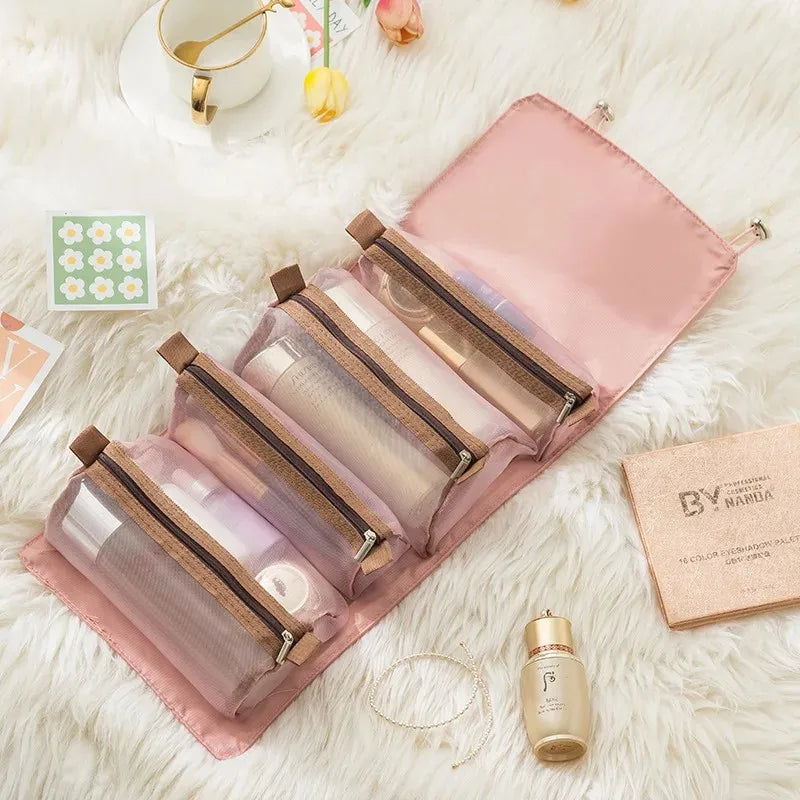 Pink 4-in-1 roll-up makeup organizer with detachable clear mesh pockets and brown zipper trim on a white faux fur rug.