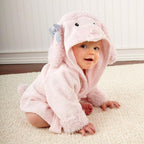 Baby in a plush, pink hooded cotton bathrobe with poodle ears and a striped bow, sitting on a white rug.