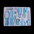 Blue baby grooming and health set in white tray: thermometer, brush, comb, scissors, nail tools, and nasal aspirator.