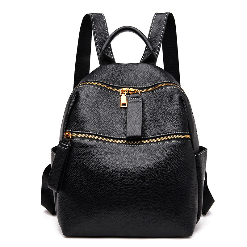 Small black pebble-grain leather women's backpack with gold zippers, top handle, and adjustable shoulder straps.
