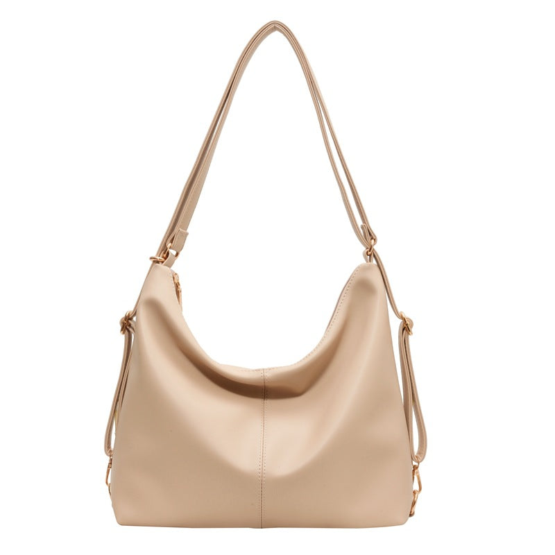 Minimalist beige PU leather hobo shoulder bag with a slouchy silhouette, gold hardware, and adjustable side straps.