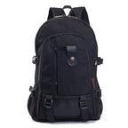 Black canvas backpack with leather-like strap details, multiple zippered pockets, side buckles, and padded straps.
